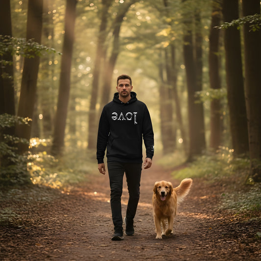 Man walking a dog in a forest with black organic hoodie featuring the design of 'LOVE' mirrored in white, by Rose Fibonacci Designs 